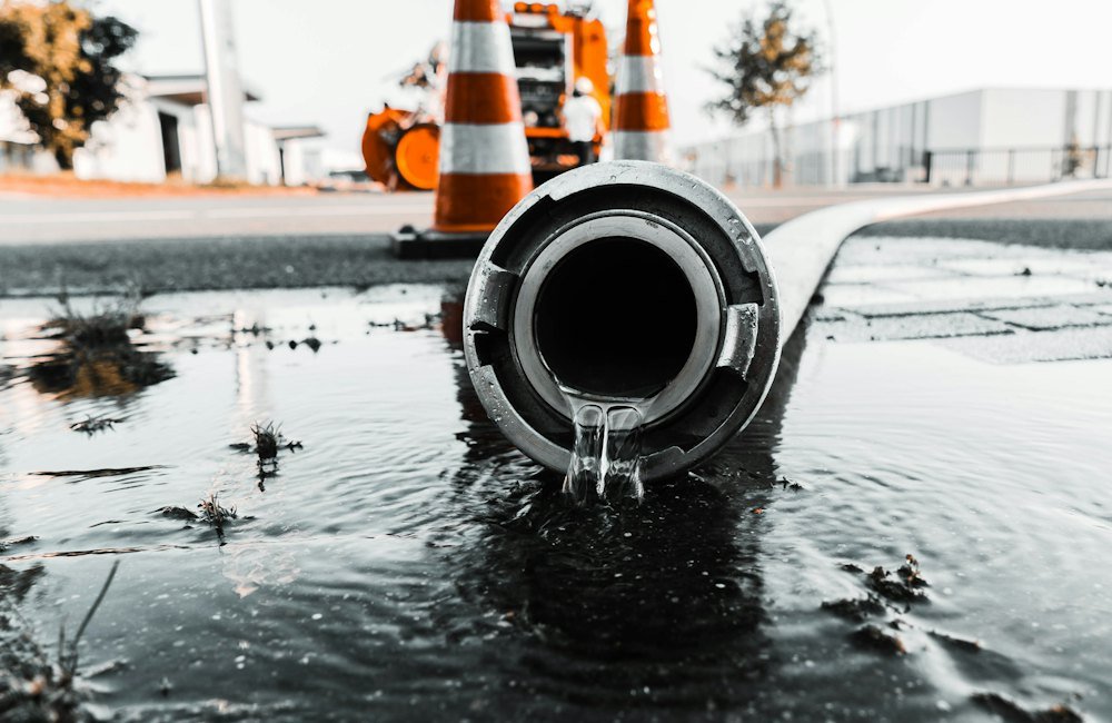 Wasser läuft aus einem Rohr auf nassen Boden